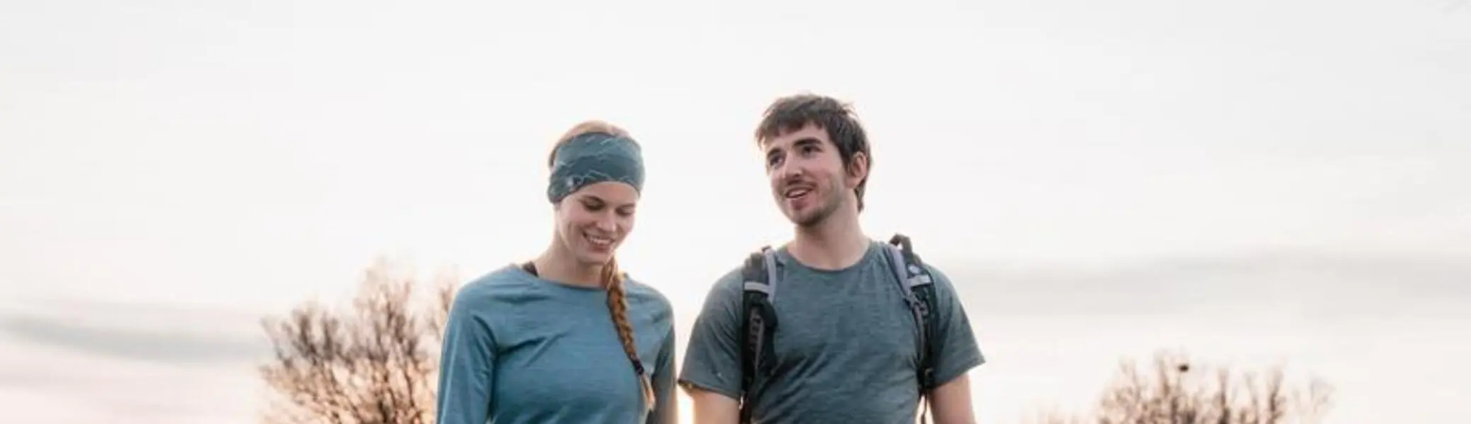 2 Personen welche über einen Steg laufen, welcher sich über einem Gewässer befindet. Im Hintergrund sind Bäume zu sehen. | © DAV/Marisa Koch