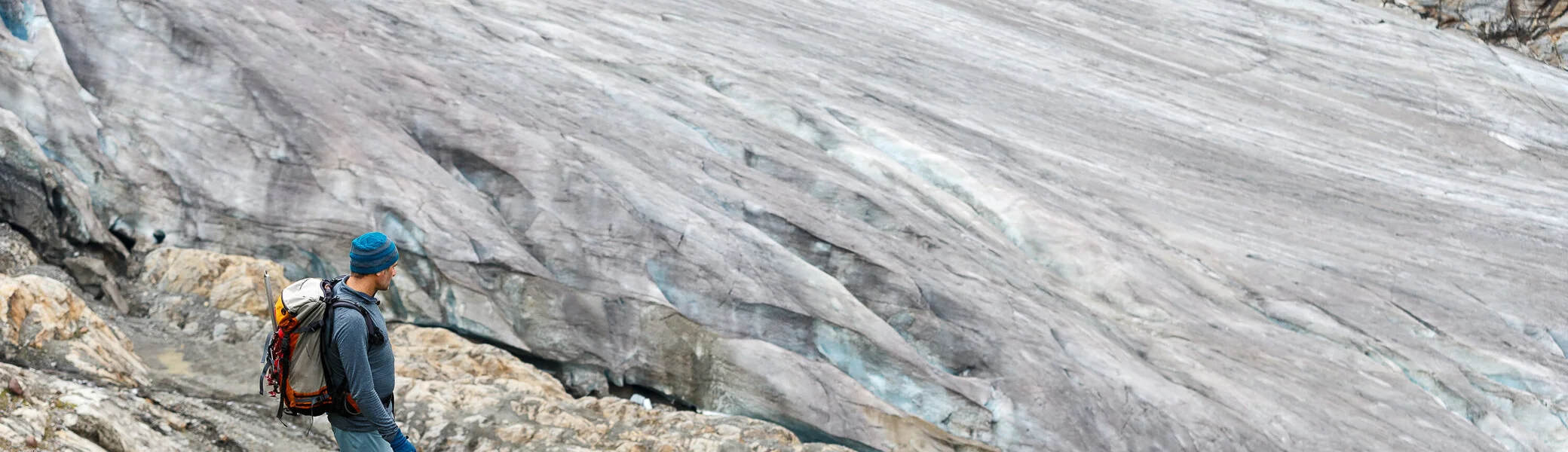 Ein Mann mit Rucksack wandert auf einem Gletscherfeld | © DAV/Marco Kost