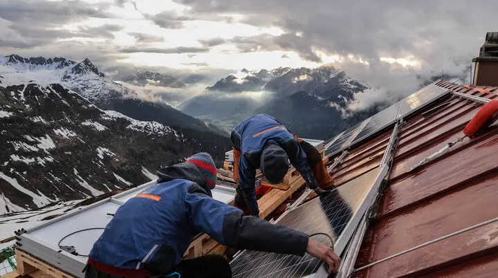 Zwei Männer reparieren das Dach einer Berghütte | © DAV / Se. Reutlingen Erl GmbH