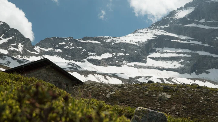 Schneebedeckte Berge, eine Hütte im Vordergrund | © DAV/Marcel Dambon